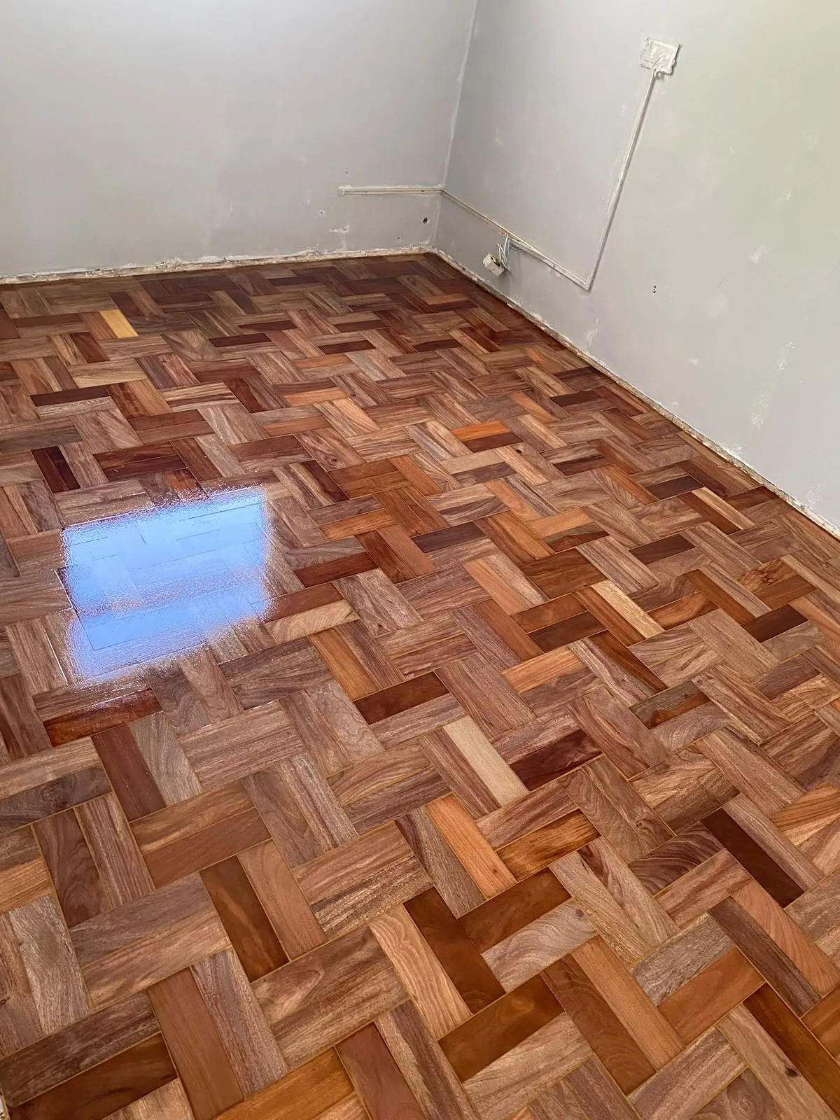 Detalhe de acabamento em piso de tacos restaurado pela EA Madeira