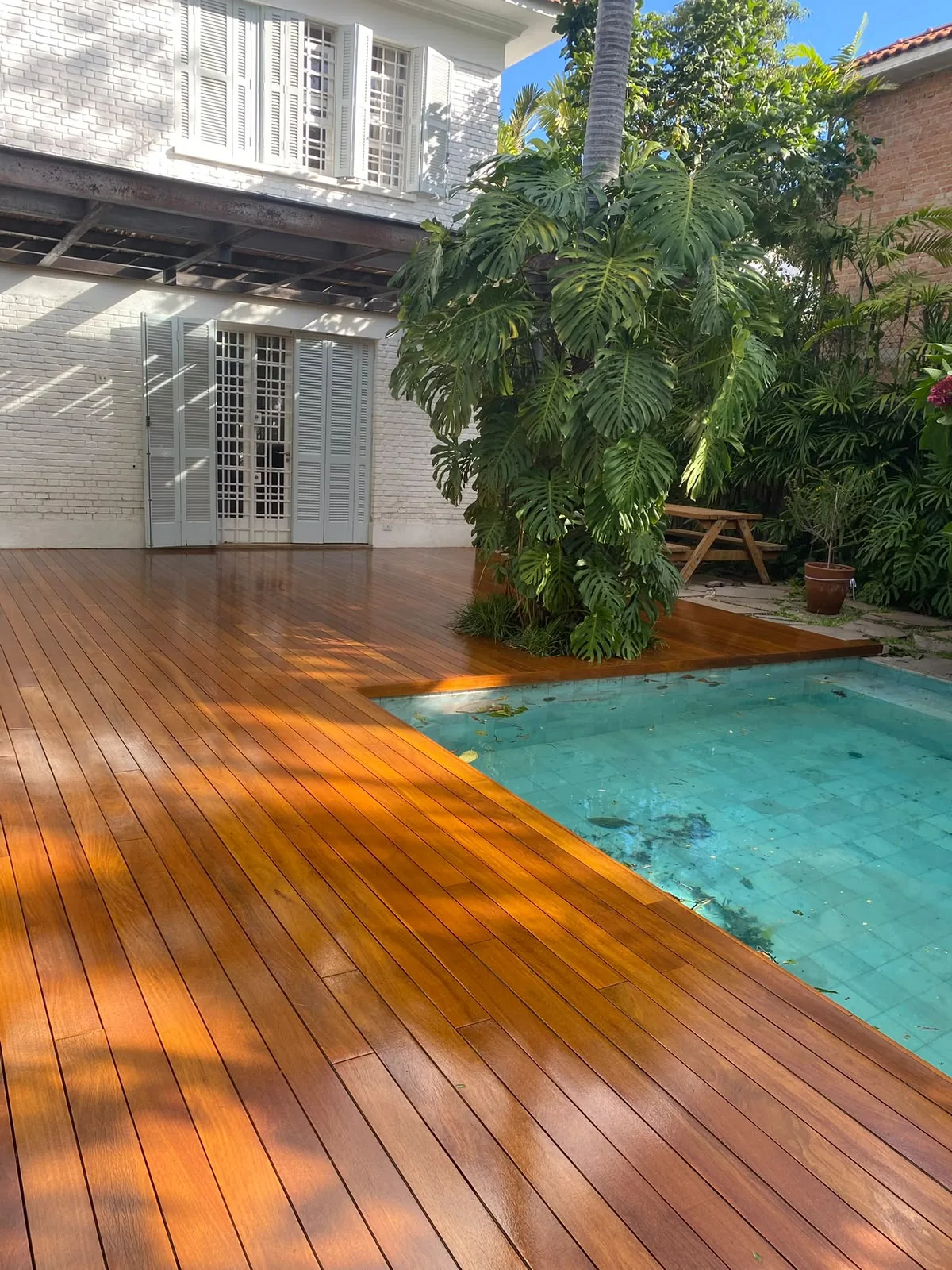 Deck de madeira restaurado em área de piscina
