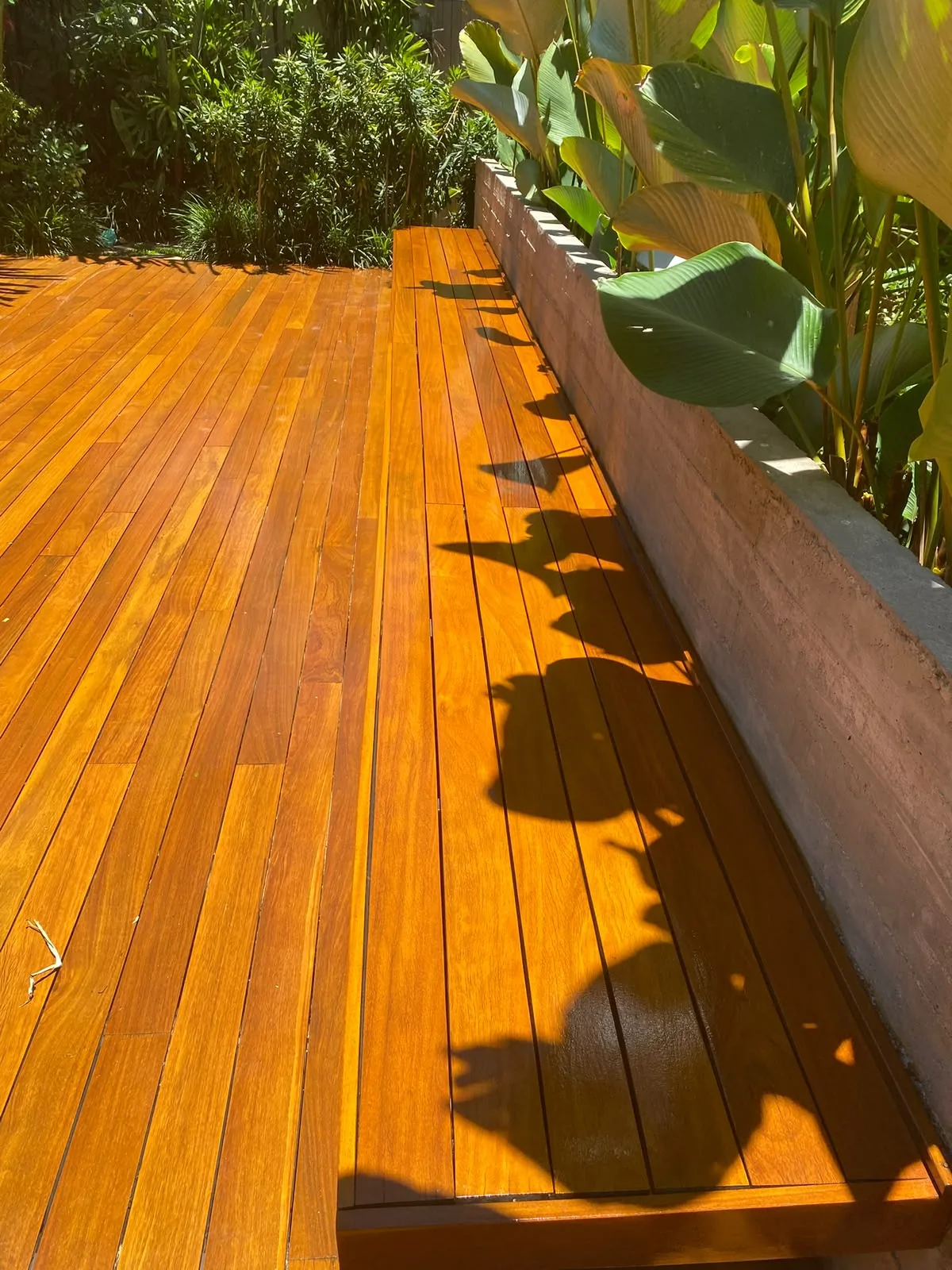 Deck de madeira restaurado em área de jardim